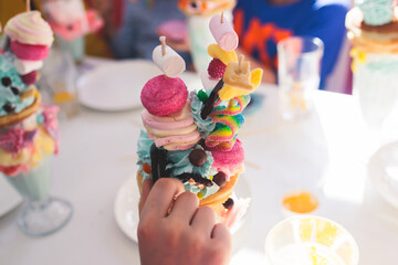 Over shake and freak shake, process of cooking extreme colorful milkshakes on a kids birthday party celebration, catering banquet table with candy sweets desserts, monster shakes