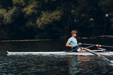 Sportsman single scull man rower rowing technique on boat. Paddle oar splash movement