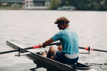Sportsman single scull man rower rowing on boat. © primipil