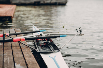 Sportsman single scull man rower prepare to competition with boat on pier - obrazy, fototapety, plakaty