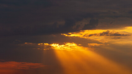 Fototapeta na wymiar Sky background at sunset. The rays of the sun break through the dark clouds.