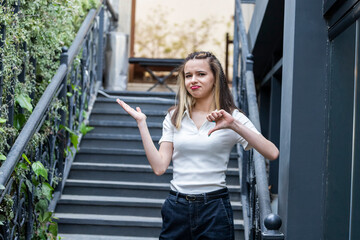 Fototapeta premium Young lady holding her hand open and gesture thumb down