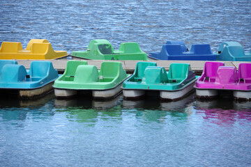 Colorful pedal boats on a lake waiting for riders