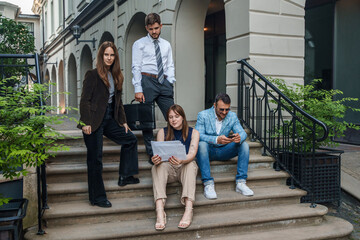 Obraz na płótnie Canvas Shot of four professional businesspeople analyzing documents outdoors in daytime.