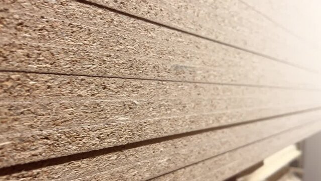Chipboard sheets stacked in the warehouse of a woodworking factory. Extreme close up shot