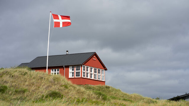 Ferienhaus in Dänemark in den Dünen, rot mit dänischer Fahne