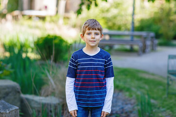 Happy little kid boy smiling. Portrait of young boy in nature, park or outdoors.