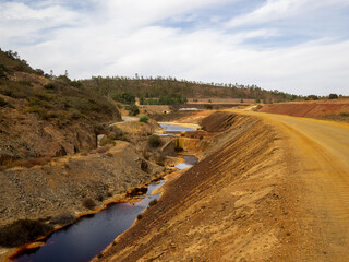 Dirt road aside a polluted water channel in Minas de S&atilde;o Domingos