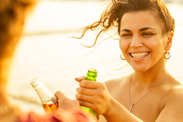 happy international friends drinking smoothie juice from glass bottle on the beach