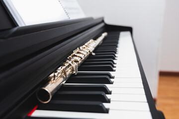 Close up of transverse flute on the keys of a piano