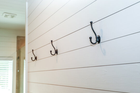 A Set Of Black Rustic Farmhouse Or Industrial Style Hanging Hooks On White Shiplap Planks In A Bathroom, Bedroom Or Closet