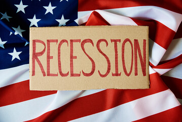 Fototapeta na wymiar Concept of recession and financial problem in USA banking system and world economic crisis,Cardboard with word recession against national american flag