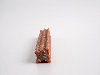 Close up dog tooth stick to reduce tartar buildup isolated on white.
