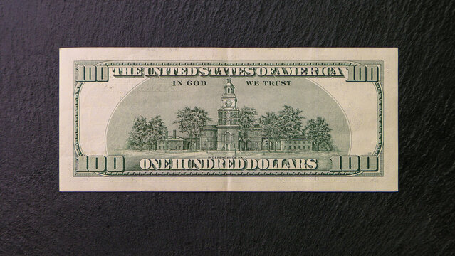 One hundred dollar bill on a black plate Back view Financial concept