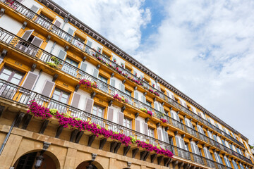 Obraz premium Beautiful old building with vibrant flowers in Donosti San Sebastian Spain