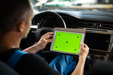 Mechanic running diagnostics software on tablet computer with green screen mockup chromakey. Unrecognizable vehicle service manager worker check and maintenance to repair the engine car in workshop © uflypro