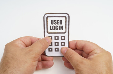 In the hands of a person is a cardboard model of a telephone with an inscription on the screen - User login
