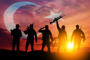 Silhouettes of soldiers on a background of Turkey flag and the sunset or the sunrise. Concept of...