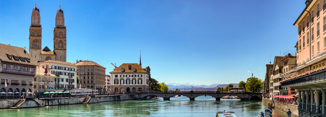 Panorama Ansicht von Zürich mit der Promenade am Limmatquai und dem Grossmünster vor den Alpen