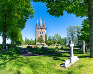 Husaby, Sweden - June 2021: Medieval Husaby Stone Church and Cemetery in Rural agricultural landscape in Skaraborg Municipitaly, Vastra Gotland Sweden.