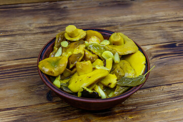Tasty marinated mushrooms on wooden table