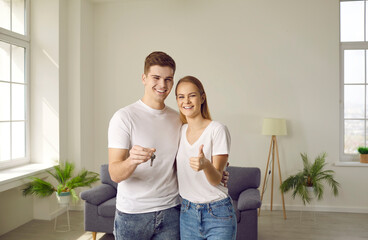 Portrait of happy joyful young family who is happy to buy home and move into new apartment. Smiling...