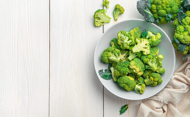 A plate of broccoli on a white wooden background. Healthy food. Cooking broccoli.
