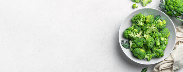 A plate of green broccoli on a gray background with space to copy. Top view, horizontal