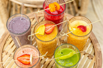 Selection of colorful smoothies and ingredients in glasses