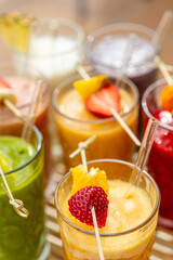Selection of colorful smoothies and ingredients in glasses