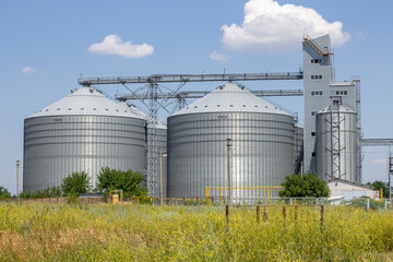Agricultural Silos. Storage and drying. Storage of crop. Grain elevator. Metal grain elevator in agricultural zone. Agriculture storage for harvest. Grain silos. Exterior of agricultural factory.