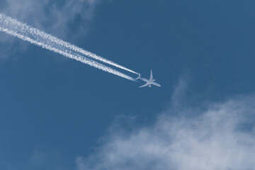 Avion de pasajeros a altitud de crucero estelando con cielo azul y nubes