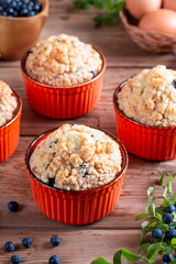 Blueberry muffins with powdered sugar and fresh berries on the table. Baked goods concept.