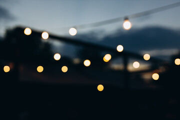 Decorative outdoor string lights at night time, Defocused Background, night city life backdrop,...