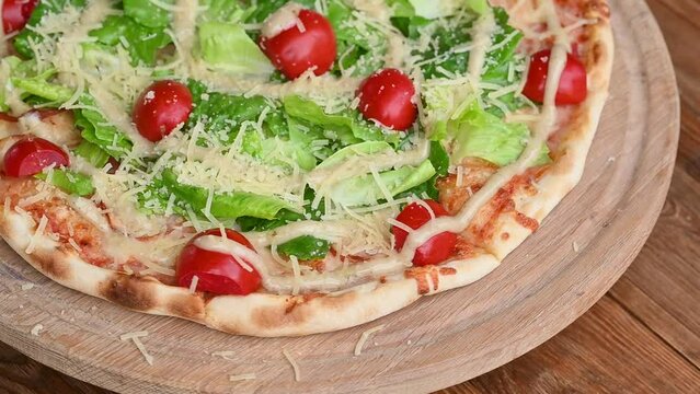 Pizza with salami and ham sausage. Italian cuisine. Side view. Free space for text. On a light wooden background. Rotates.