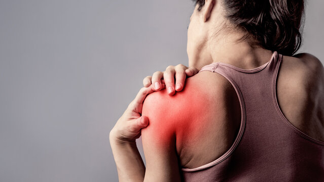 Young strong sporty woman doing the hands the  to relax the tension shoulder and blades in sport wear with red highlighted on empty copy space. Sports exercising injury.  concept of medicine