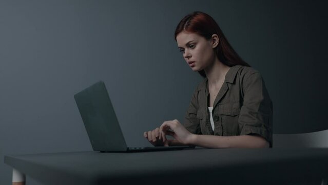 Woman businesswoman freelancer works online at a table behind a laptop and is sad. Depression from work and finances during a crisis