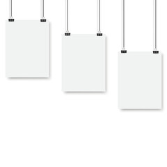 Blank posters hanging on a binder clips. A4 white paper sheet hangs on a rope with clips