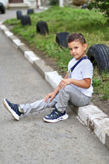 Handsome little boy sitting and posing for the camera. Carefree childhood.