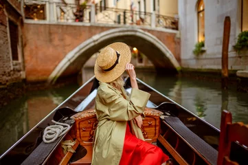 Foto op Plexiglas Gondels Achteraanzicht, achteraanzicht van elegante vrouw met strohoed op Gondola-rit langs prachtige straat in Venetië, Italië. Reizen, vakantie, levensstijl conceptie. Kopiëren, lege ruimte voor tekst