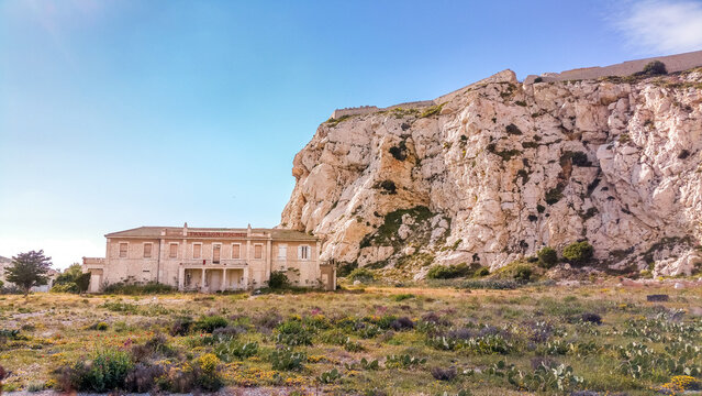 Abandoned buildings under rocky cliff in frioul islands near the city of marseille
