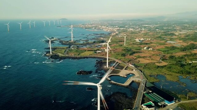 Landscape of coast with wind generator in Woljeong-ri, Jeju, Korea. Jeju Island is famous for beautiful nature and natural World heritage sites. (aerial photography)