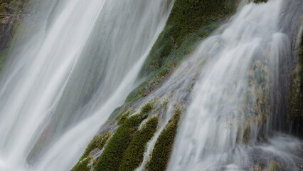 Beautiful waterfall splashing over mossy rocks