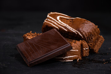 Sliced homemade chocolate biscuit roll with a piece of chocolate 
