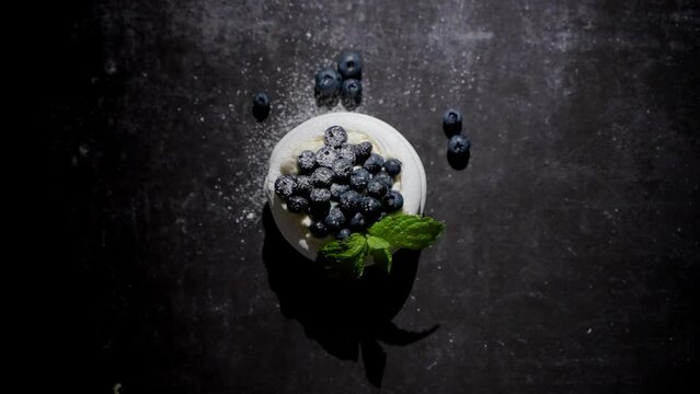 Mini meringue dessert pavlova cake with fresh blueberries plased on dark rusty table