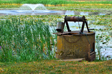 old water well with pulley and bucket in european village. Selective focus.