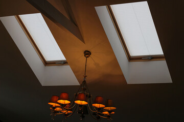 Pleated blinds automatic on roof windows close up in the interior. Motorized blinds for skylights....