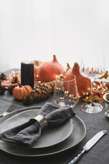Halloween and Thanksgiving day dinner decorated fallen leaves, pumpkins, spices, grey plate. Close up. Vertical format.