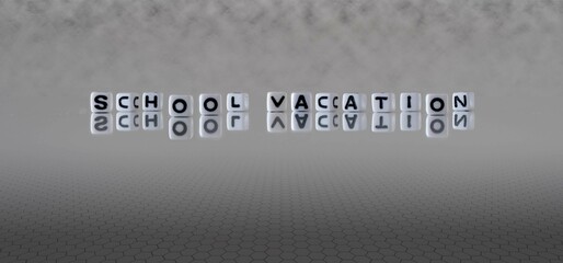 school vacation word or concept represented by black and white letter cubes on a grey horizon background stretching to infinity