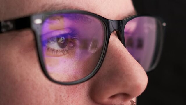 Man in the glasses watches to the monitor. Reflection in the googles.